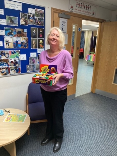 Headteacher Lisa Hall holding Sir Oliver's donated box of Charlie Chicks creme eggs